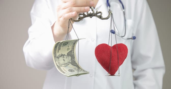 doctor-holding-scale-with-heart-and-money